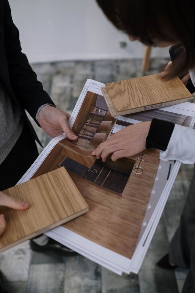 تشطيب مشاريع سكنية: كيف تُدار من البداية حتى التسليم؟ فريق تصميم يراجع مخططات المشروع وعينات مواد التشطيب
